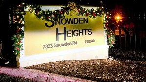 A sign for Snowden Heights with a Christmas decoration.