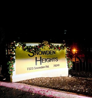 Snowden Heights sign at night, featuring festive decorations.