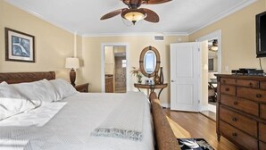 A bedroom with a bed, a ceiling fan, a dresser, and a television. - Crystal Sands Tower Unit 703 - Beachfront (Sarasota)