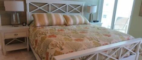 A bedroom with a bed, nightstands, and a window.