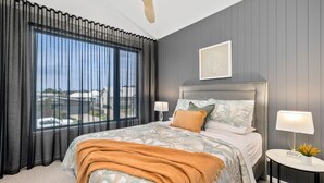 A hotel room with a large bed, a nightstand, a lamp, and a view of the outside. - Apartment Studio 6: In The Heart of Torquay (Torquay)