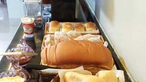 Una taula de buffet amb diversos productes de forneria, com pa de mos i pastissos.