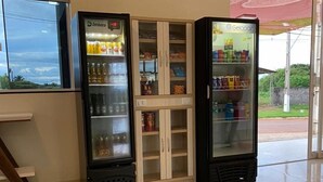Zona de màquines expenedores amb un frigorífic i un congelador, amb begudes i llaminatures.
