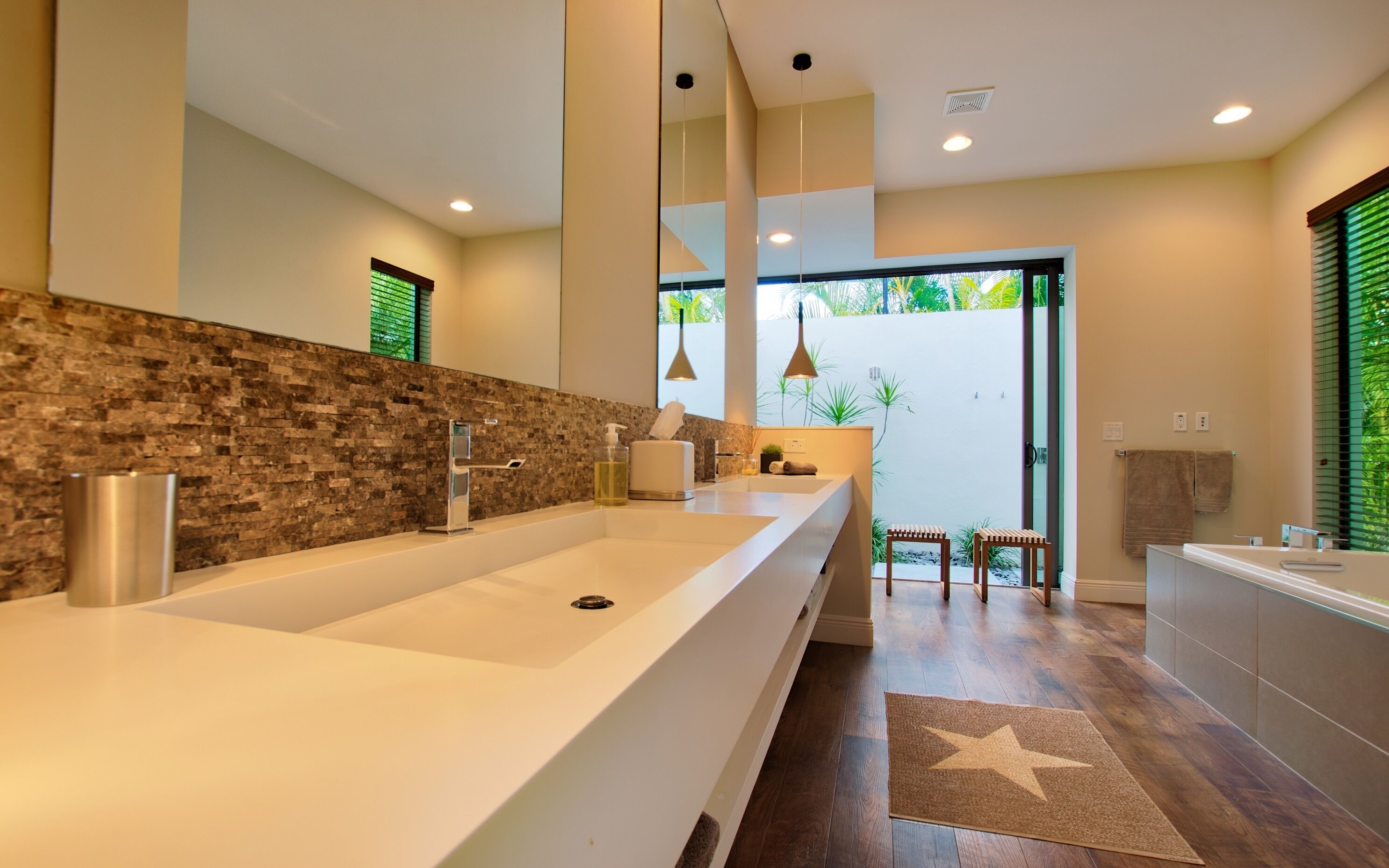 Un baño moderno con un lavamanos grande, un espejo y una zona de ducha.