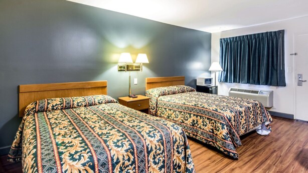 A hotel room with two beds, a wall-mounted TV, a heater, and two bedside lamps. - Econo Lodge near Richmond National Battlefield Park (Richmond)