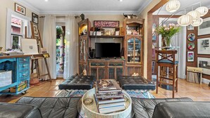 Ein Wohnzimmer mit Fernseher, Büchern und einem Couchtisch.