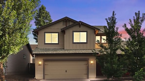 A two-story house with a garage, a visible address number, and a well-maintained lawn.