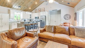 A spacious living area with leather sofas, a wooden ceiling, and a kitchen in the background. - Deck, Fire Pit & Fireplace: Murphy Forest Retreat (Murphy)