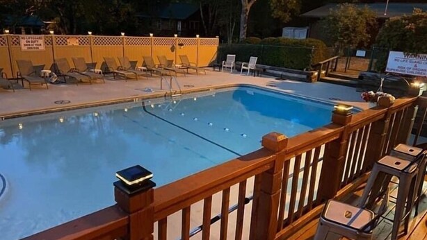 A swimming pool with lounge chairs and a wooden deck. - North Georgia Mountain Getaway (Cleveland)