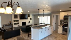 A modern kitchen with white cabinets, a central island, and stainless steel appliances.
