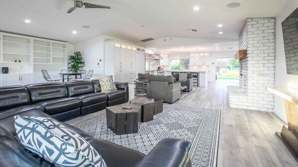 A modern living room with a black leather sofa, a patterned rug, and a coffee table.