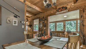 A rustic wooden cabin interior with a dining table set for four, surrounded by wooden chairs. - Rustic Cabin trout fishing dog loving beach area on secluded 8 acres! HL# 001504 (Ellijay)