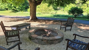 Un foyer circulaire, entouré de quatre bancs en bois.