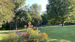 Un jardin bien entretenu, agrémenté de diverses plantes à fleurs et bordé d’une allée circulaire en pierre.