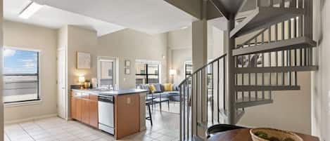 Cozy living space with a central kitchen island and adjacent living area featuring a sofa and coffee table.