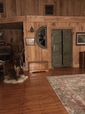 Cozy retreat with a round window, wooden paneling, and a comfortable bench.