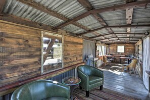 Cozy seating area with leather chairs and a dining table, surrounded by wooden panels and a large window.