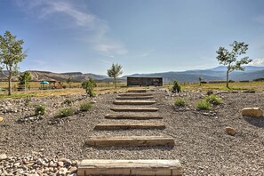Stroll along the serene pathway to a cozy retreat, surrounded by lush trees and rolling hills.
