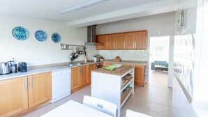 A modern kitchen with wooden cabinets, a white countertop, and a built-in oven.