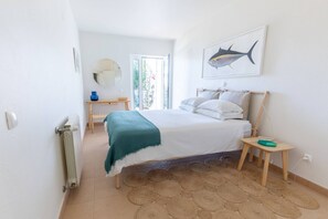 A bedroom with a bed, bedside table, and a wall-mounted fish illustration. - CoolHouses Algarve Luz | Casa da Praia (Luz)