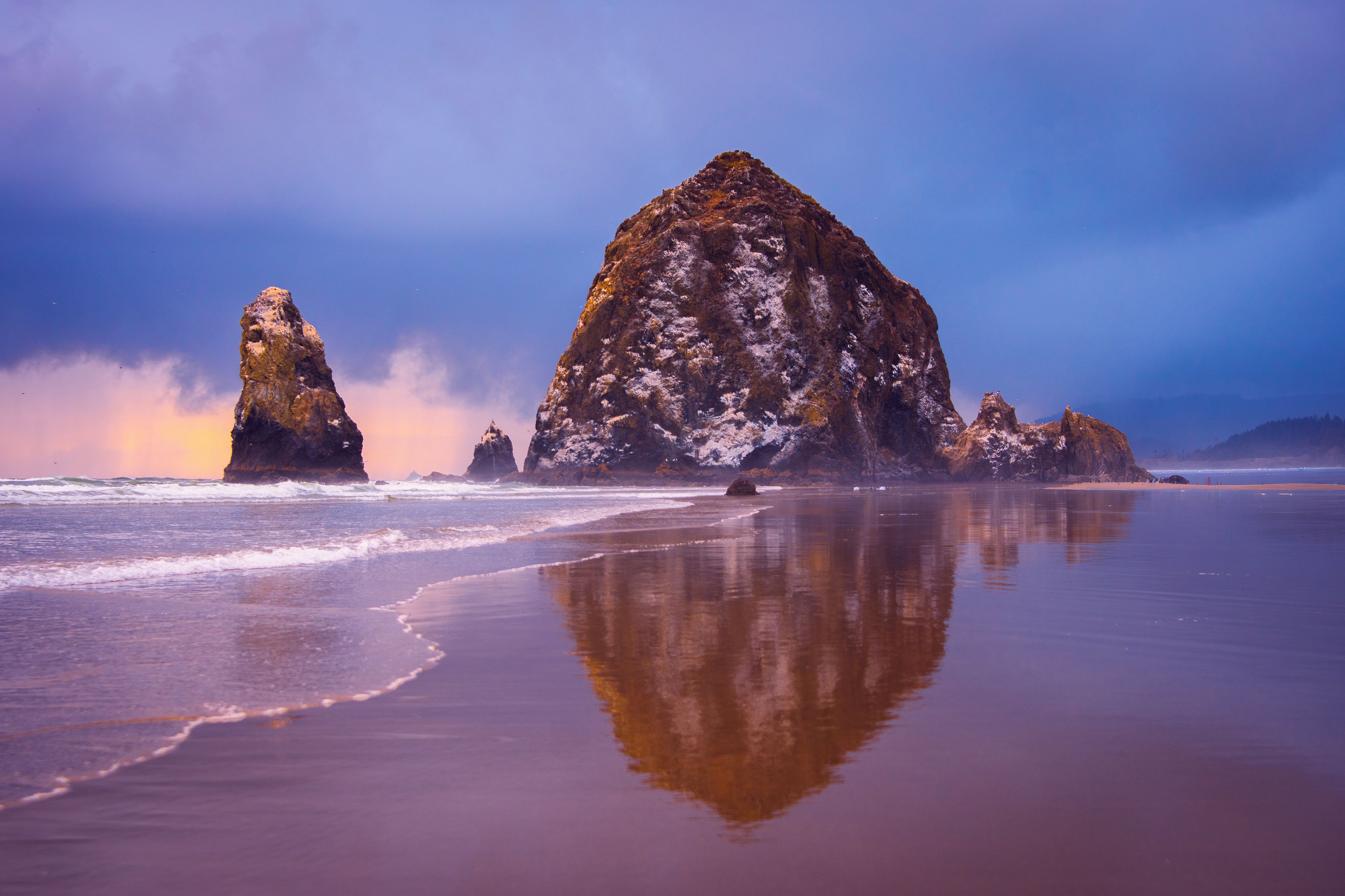 A beach with large rock formations and calm waters.