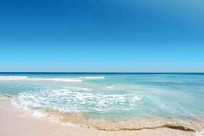 Uma praia com águas azul-claras e um areal.