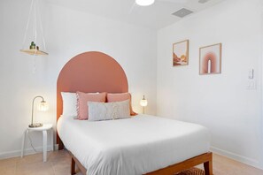 A bedroom with a bed, two bedside tables, a hanging light fixture, and two wall-mounted picture frames. - Golden Desert Ranch - Hot Tub, Fire Pit and BBQ (Joshua Tree)