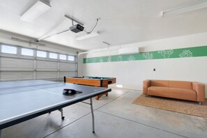 A spacious indoor area with a ping pong table, a pool table, and a sofa. - Golden Desert Ranch - Hot Tub, Fire Pit and BBQ (Joshua Tree)