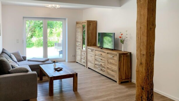 Un salon moderne comprenant un canapé, une table basse, un meuble en bois et un téléviseur.