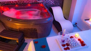 A hot tub with a control panel, a white chair, a tray with rose petals and chocolates, and a bottle of champagne. - Apartment with Jacuzzi near the beach, Arenales (Los Arenales del Sol)