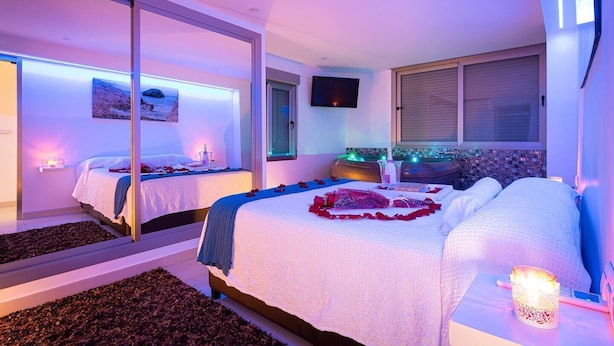 A modern bedroom with two beds, a large window, and a city view. - Apartment with Jacuzzi near the beach, Arenales (Los Arenales del Sol)