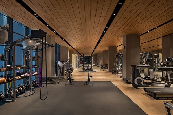A gym with various exercise equipment, including treadmills and weight machines, and a wall of kettlebells. - Shangri-La Shougang Park, Beijing (Beijing)