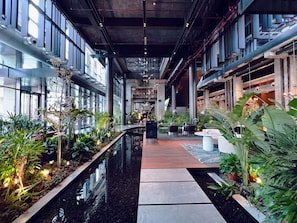 A modern indoor space with a central water feature, seating areas, and abundant indoor plants. - Shangri-La Shougang Park, Beijing (Beijing)