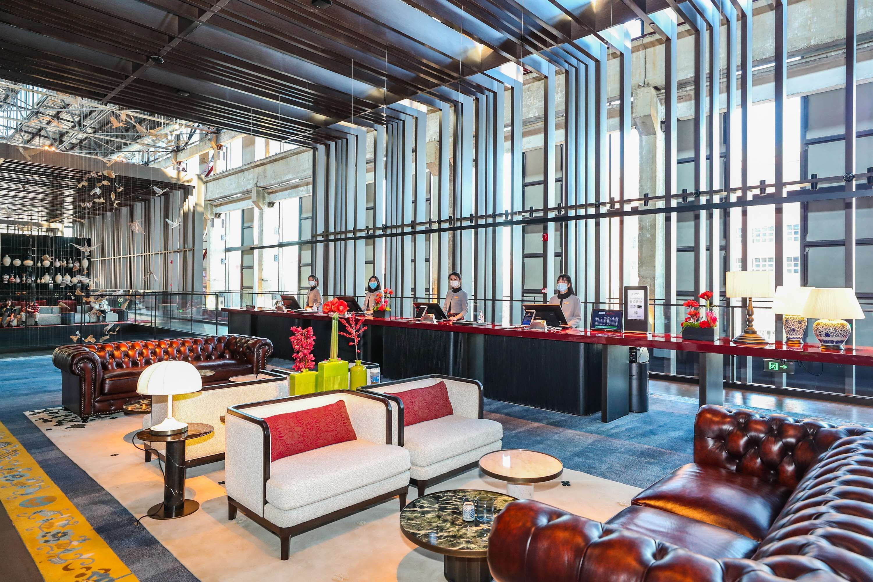 A spacious lobby with leather sofas, a bar area, and large windows.