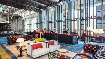 A spacious lobby with leather sofas, a bar area, and large windows.
