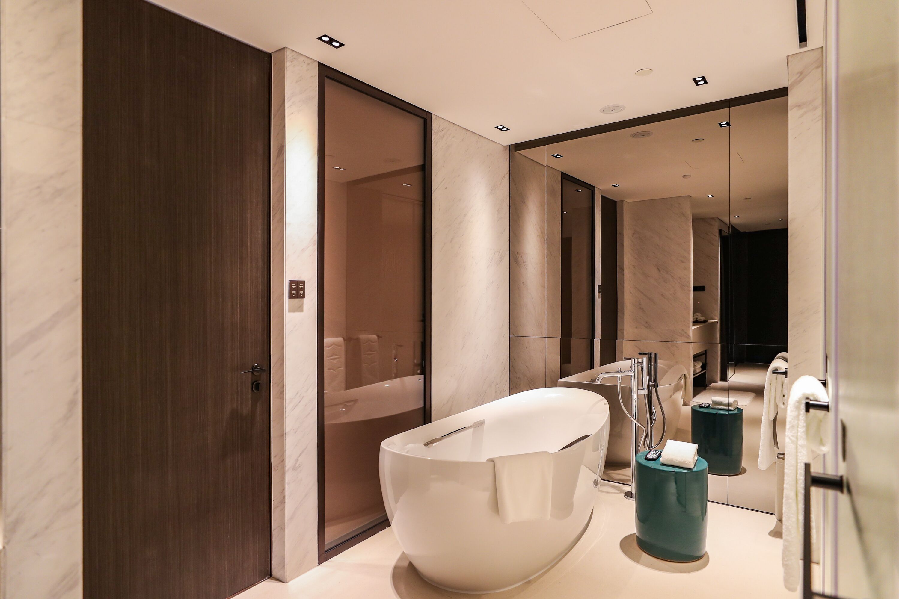 A modern bathroom with a large white bathtub, a separate shower area, and a vanity with a mirror.
