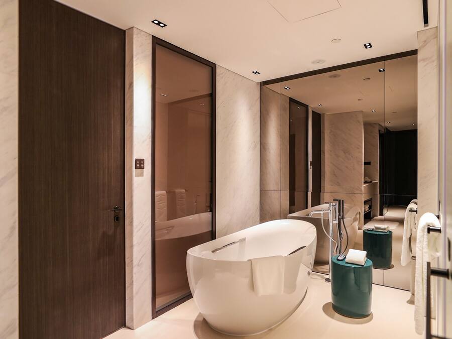 A modern bathroom with a large white bathtub, a separate shower area, and a vanity with a mirror.