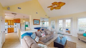 A spacious living room with a sofa, a coffee table, and a dining area with chairs.