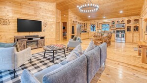 A wooden cabin interior with a living room, dining area, kitchen, and a TV mounted on the wall. - 5 mins to DWTN & Lake, Arcade, Foosball. Best Location in Blue Ridge (Blue Ridge)