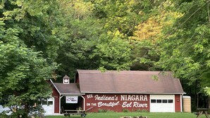 A red building with a sign reading "Indiana's Niagara on the Beauford El River."