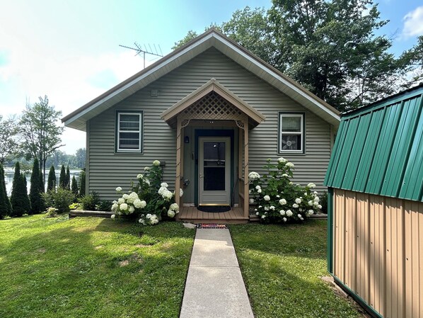 A single-story house with a front door, two windows, and a small porch.