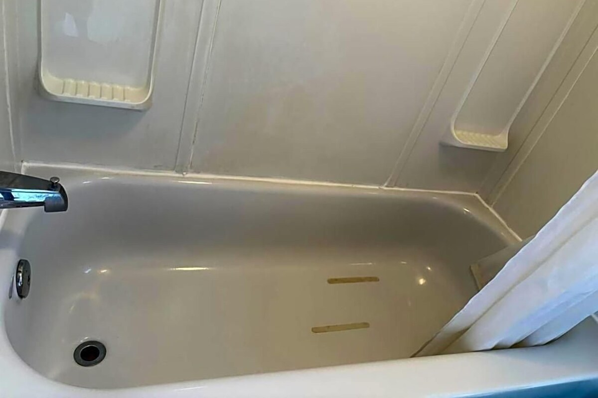 A bathtub with a faucet and a drain.