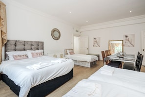 Une chambre d’hôtel avec deux lits, une table à manger et un miroir.