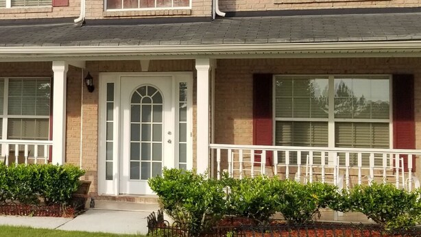 A two-story house with a front porch, a garage, and a well-maintained lawn. - Welcome to Eve's Place. Come enjoy the historic township of Conyers. (Conyers)