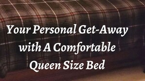 A queen size bed with a plaid bedspread and red pillows, a bedside lamp, and a window with sheer curtains. - Welcome to Eve's Place. Come enjoy the historic township of Conyers. (Conyers)