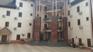 A multi-story building with a central entrance flanked by two columns, multiple balconies, and air conditioning units. - Royal City Dubai Hotel & Suites (Nkpor)