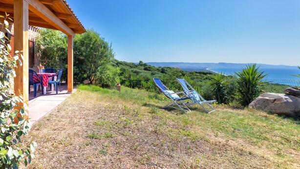 Un patio con una pérgola de madera, una mesa con sillas y dos sillones de descanso.
