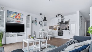 A modern living room with a TV, sofa, and dining area.