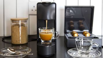 Eine Kaffeemaschine brüht Kaffee in ein Glas, eine Kaffeebohnen-Glas und eine Espressomaschine mit Brühgruppe.
