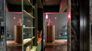 Um hall de hotel moderno com área de estar central, vitrines de vidro e um balcão de recepção de mármore.